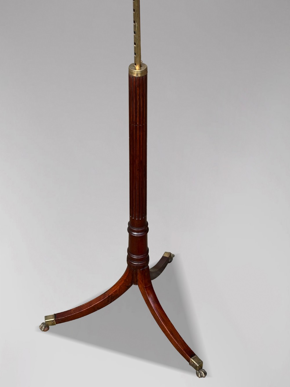 A 19th-century Regency mahogany duet music stand featuring a double-sided lattice desk, adjustable brass column, fluted stem, and tripod base with brass castors. View VII