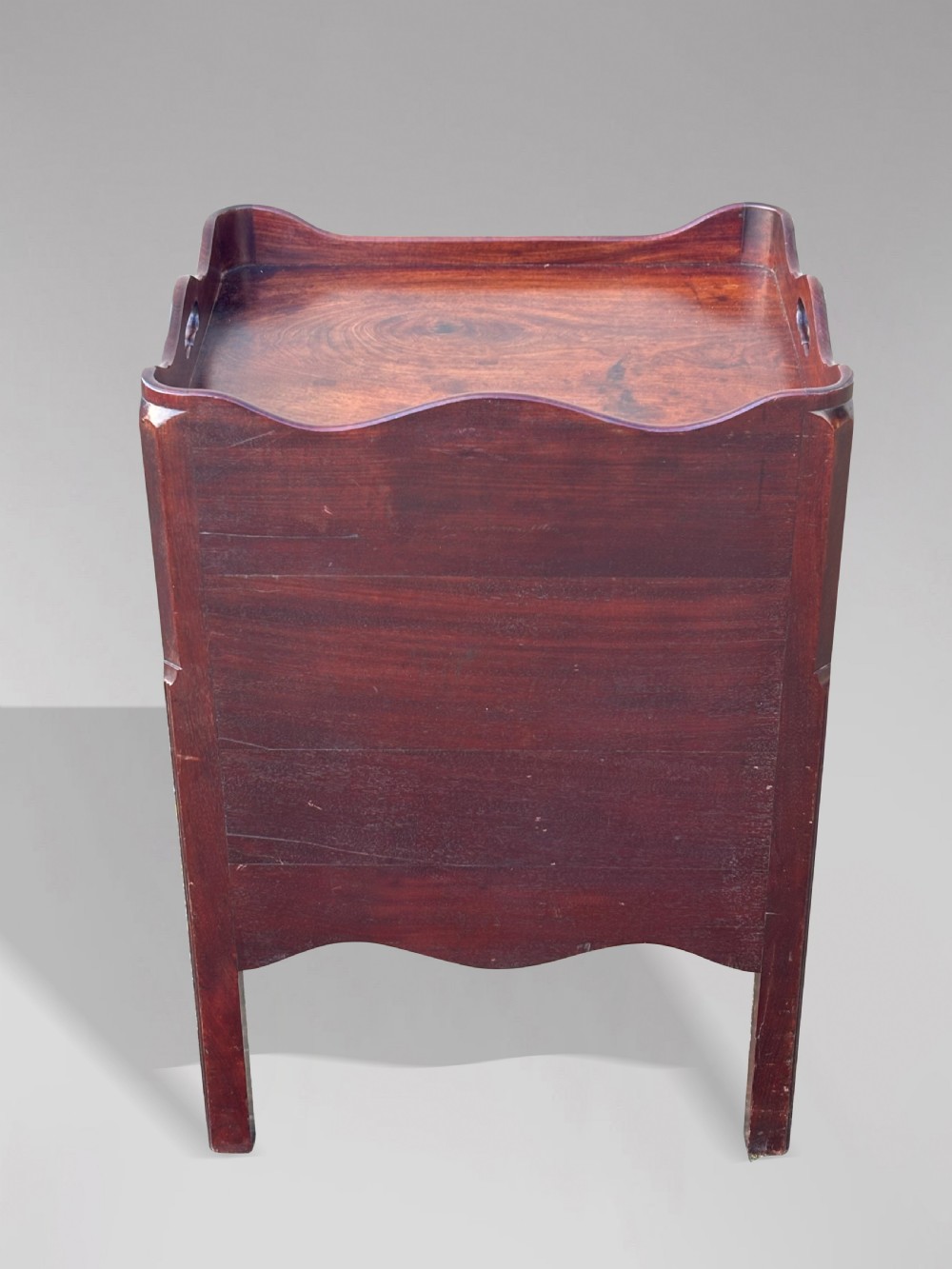 An 18th-century George III mahogany tray-top commode featuring shaped gallery sides, a cupboard with twin panel doors, a lower drawer with brass swan-neck handle, and square legs. View XI