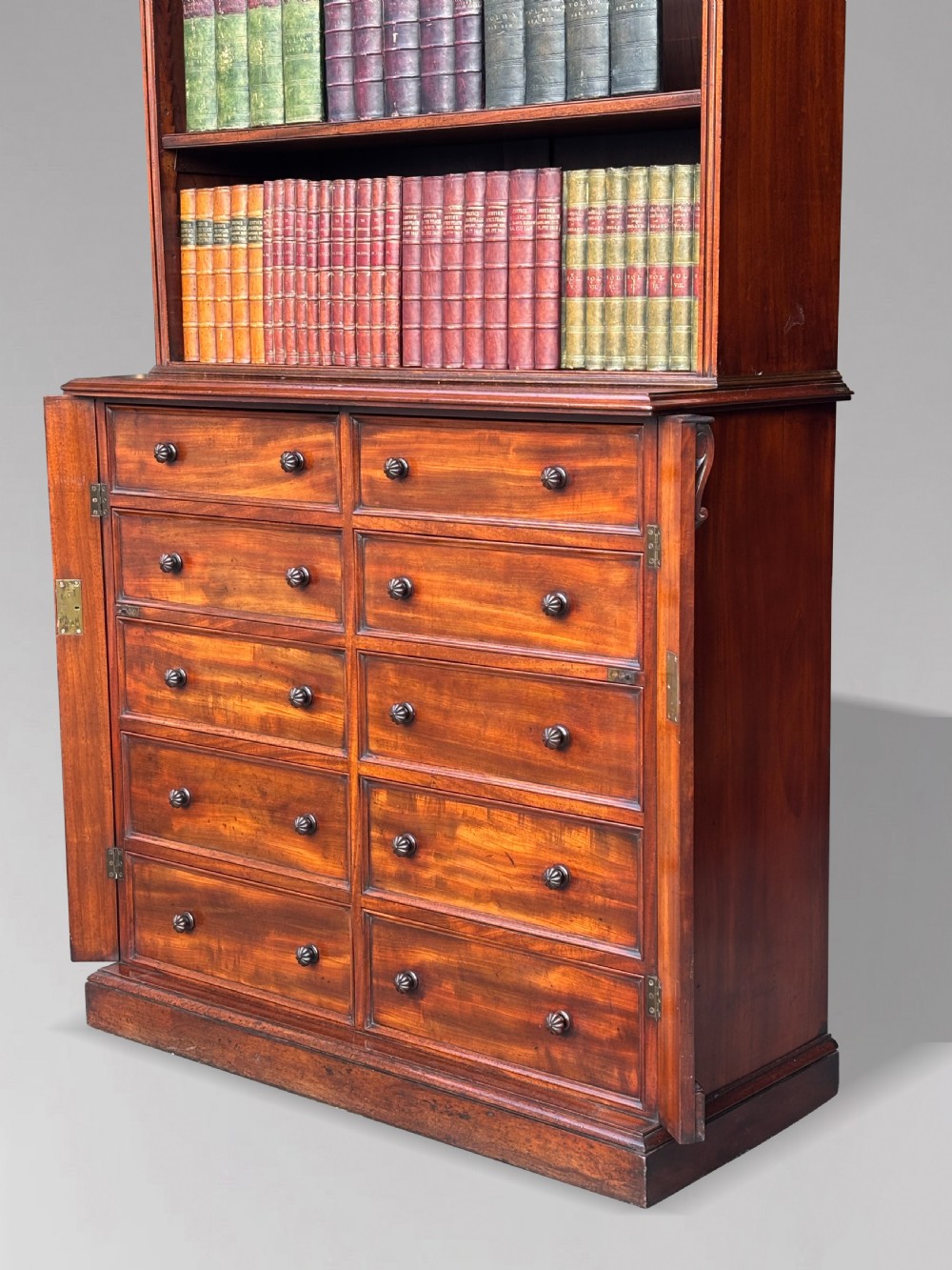 A nineteenth-century mahogany open library bookcase featuring a Wellington chest base with ten small drawers and open adjustable upper shelves. View XVIII
