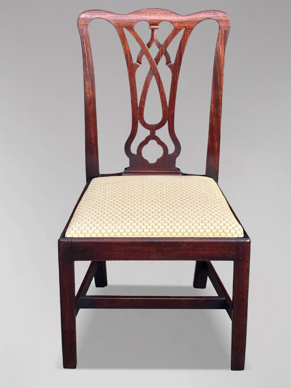 A set of eight George IV mahogany dining chairs with pierced fretwork splats and light cream upholstered drop-in seats. View IV