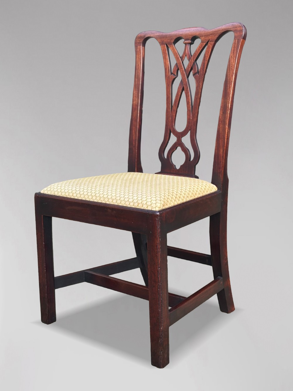 A set of eight George IV mahogany dining chairs with pierced fretwork splats and light cream upholstered drop-in seats. View VII