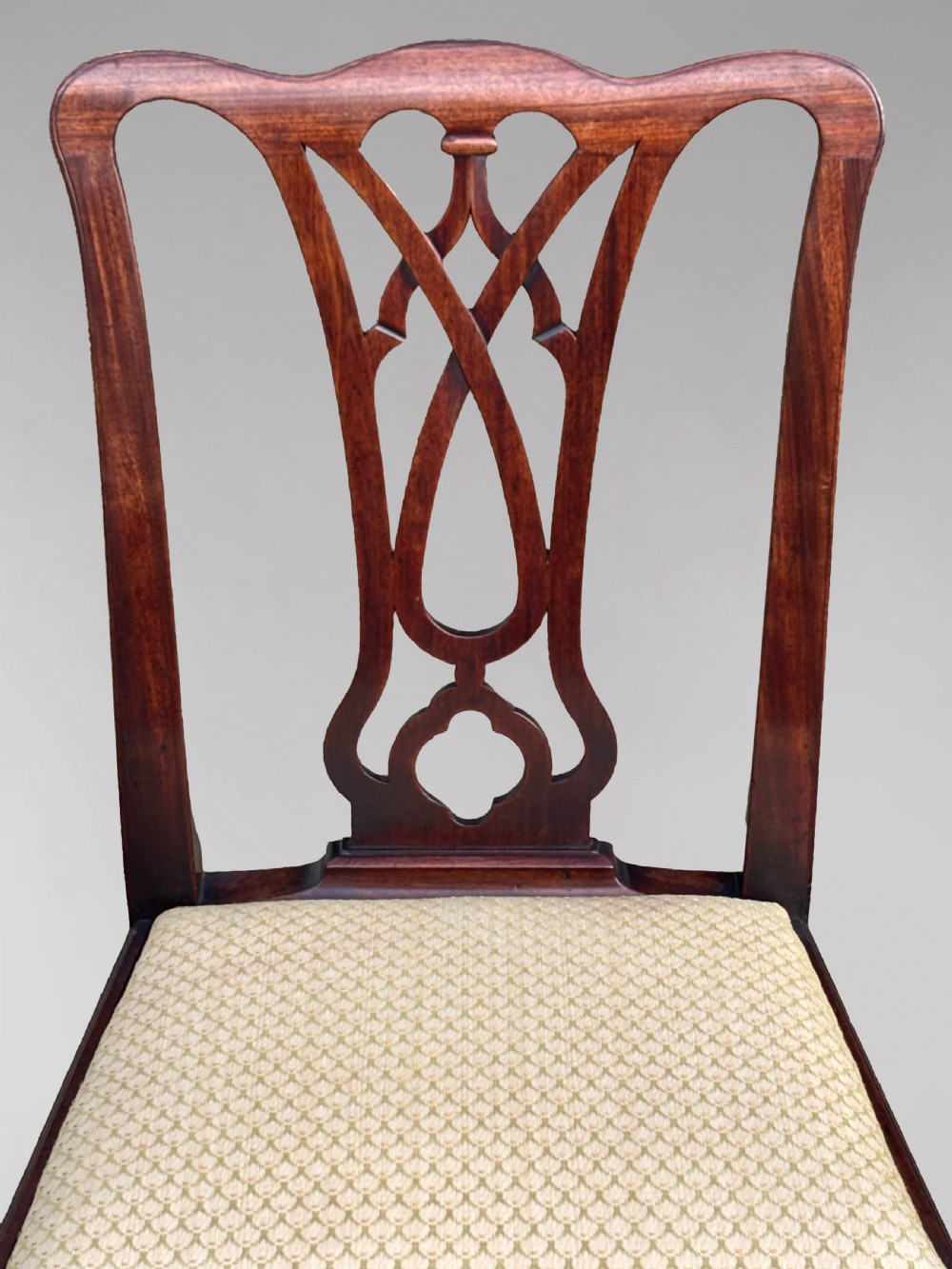 A set of eight George IV mahogany dining chairs with pierced fretwork splats and light cream upholstered drop-in seats. View VIII
