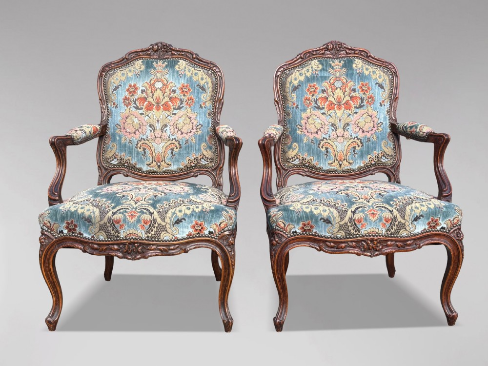 A set of four 19th-century French Louis XV style fauteuil armchairs featuring carved timber frames, cabriole legs, and blue floral upholstery. View II
