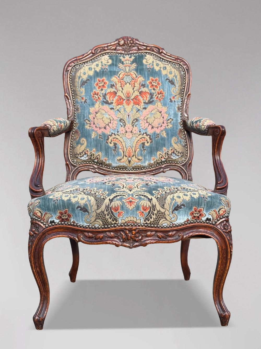 A set of four 19th-century French Louis XV style fauteuil armchairs featuring carved timber frames, cabriole legs, and blue floral upholstery. View III