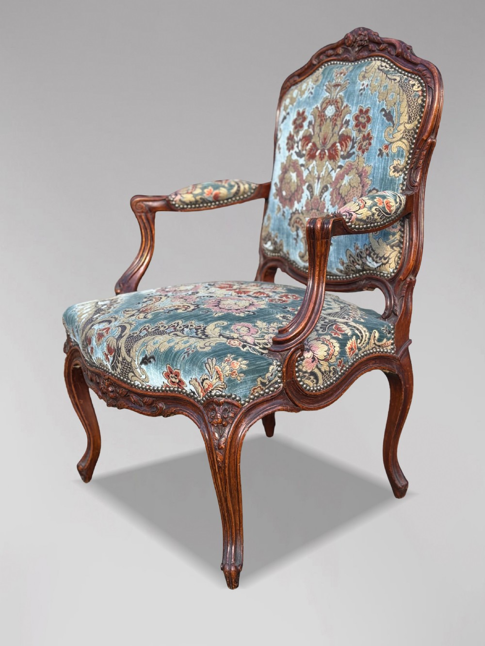 A set of four 19th-century French Louis XV style fauteuil armchairs featuring carved timber frames, cabriole legs, and blue floral upholstery. View IV