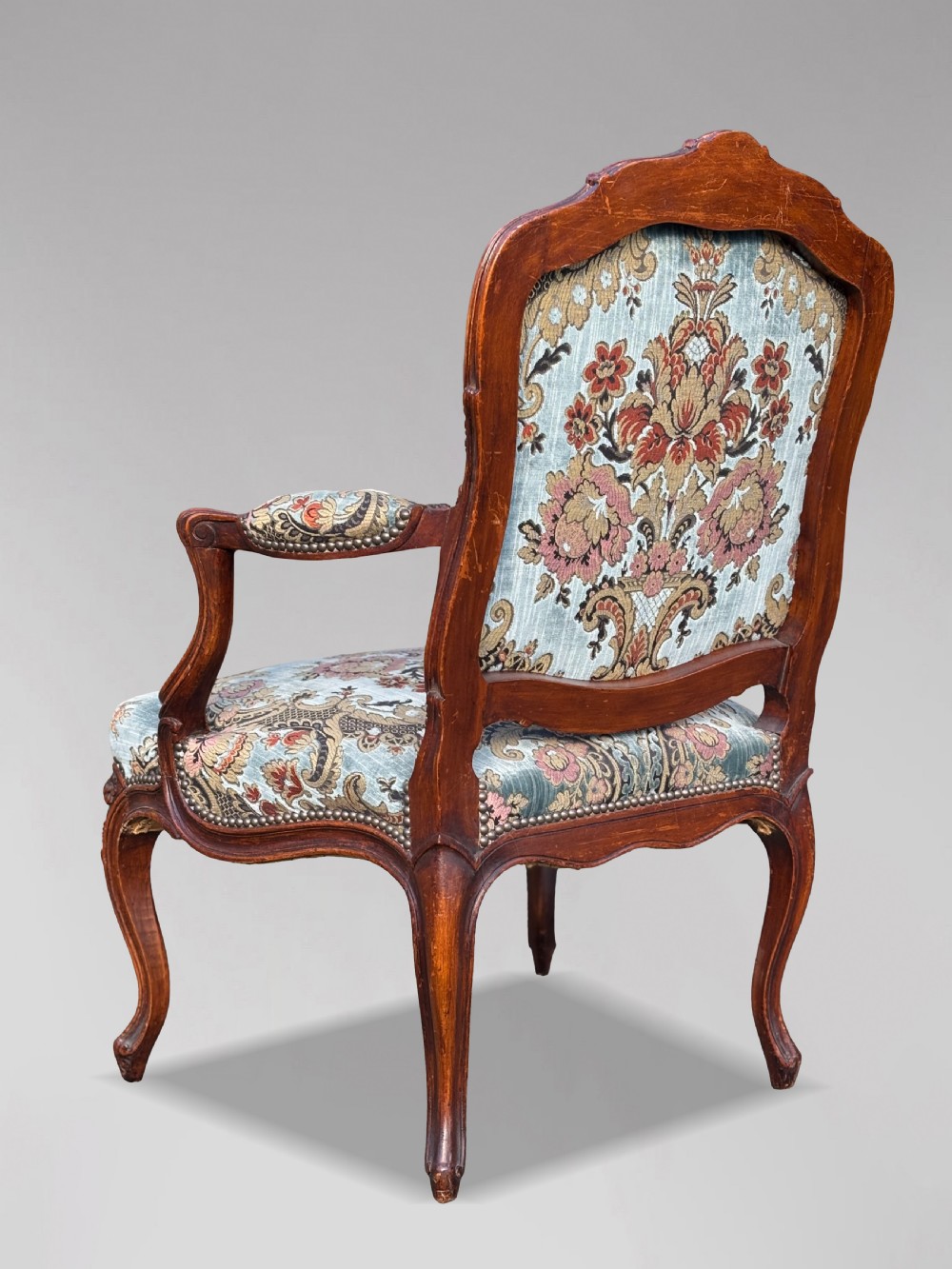 A set of four 19th-century French Louis XV style fauteuil armchairs featuring carved timber frames, cabriole legs, and blue floral upholstery. View V