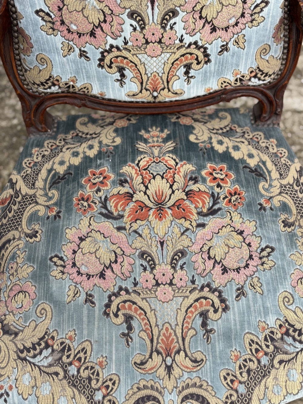 A set of four 19th-century French Louis XV style fauteuil armchairs featuring carved timber frames, cabriole legs, and blue floral upholstery. View VI