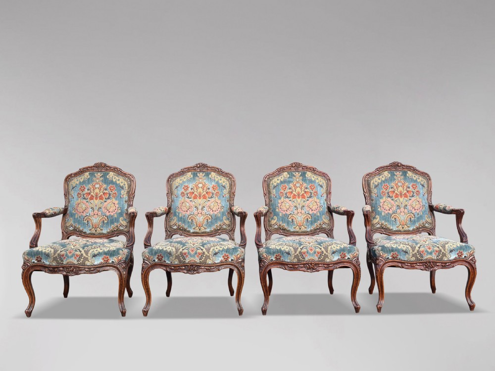 A set of four 19th-century French Louis XV style fauteuil armchairs featuring carved timber frames, cabriole legs, and blue floral upholstery. View VII