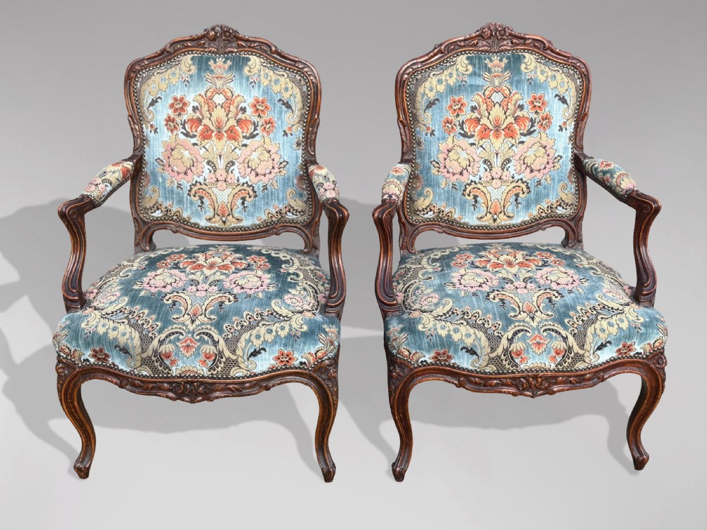 A set of four 19th-century French Louis XV style fauteuil armchairs featuring carved timber frames, cabriole legs, and blue floral upholstery. View IX