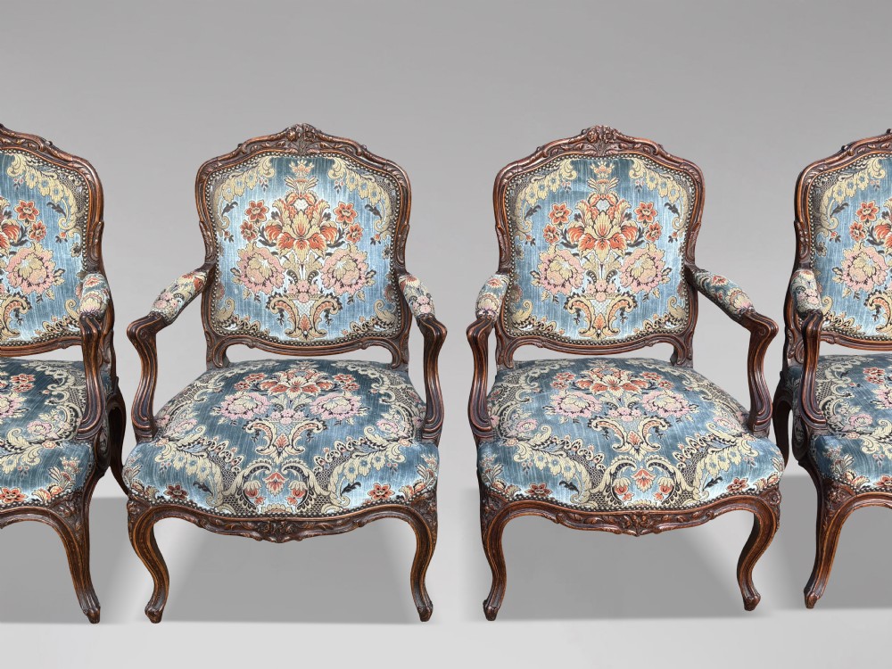 A set of four 19th-century French Louis XV style fauteuil armchairs featuring carved timber frames, cabriole legs, and blue floral upholstery. View XII