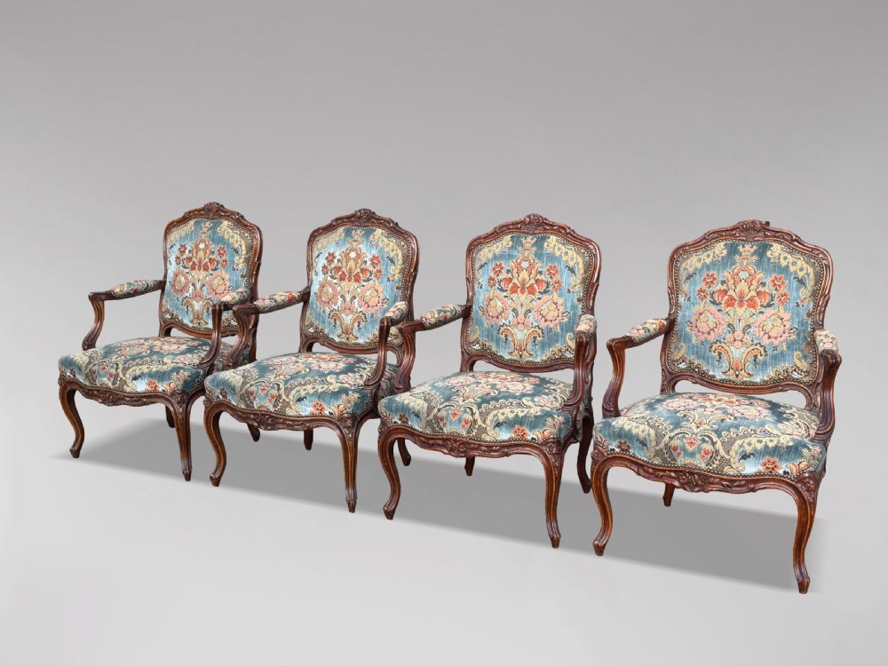 A set of four 19th-century French Louis XV style fauteuil armchairs featuring carved timber frames, cabriole legs, and blue floral upholstery. View XIII