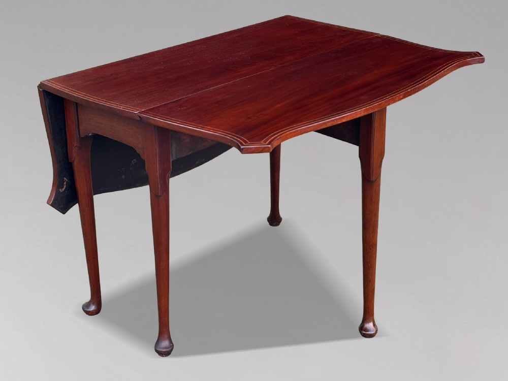An 18th-century George III mahogany drop-leaf table featuring shaped corner edges with fine stringing inlay and slender legs terminating in pad feet. View III