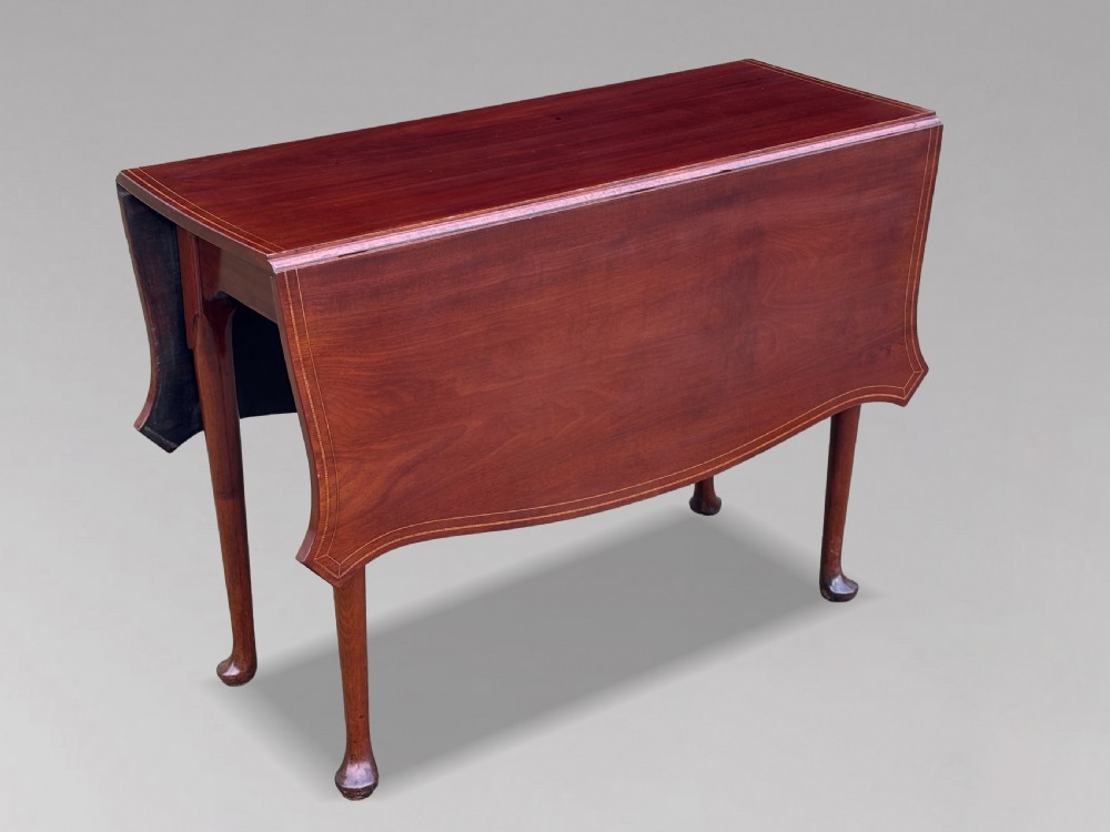 An 18th-century George III mahogany drop-leaf table featuring shaped corner edges with fine stringing inlay and slender legs terminating in pad feet. View IV