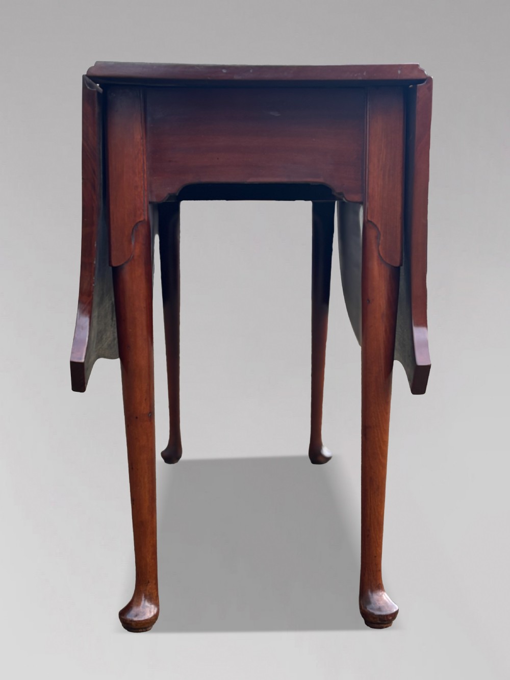 An 18th-century George III mahogany drop-leaf table featuring shaped corner edges with fine stringing inlay and slender legs terminating in pad feet. View VI