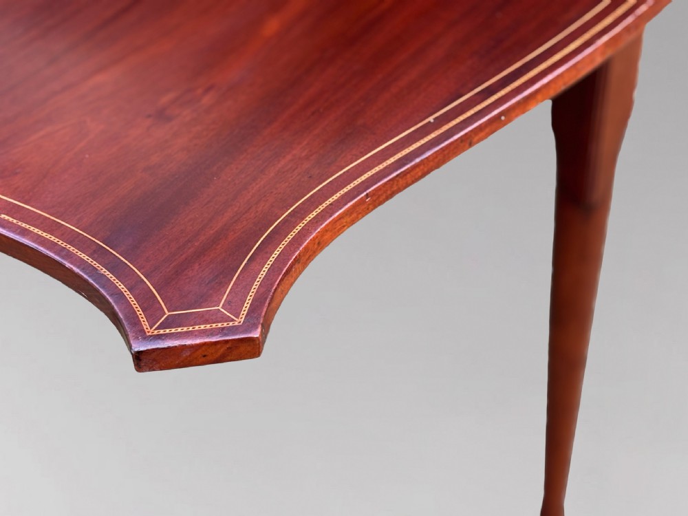 An 18th-century George III mahogany drop-leaf table featuring shaped corner edges with fine stringing inlay and slender legs terminating in pad feet. View VII