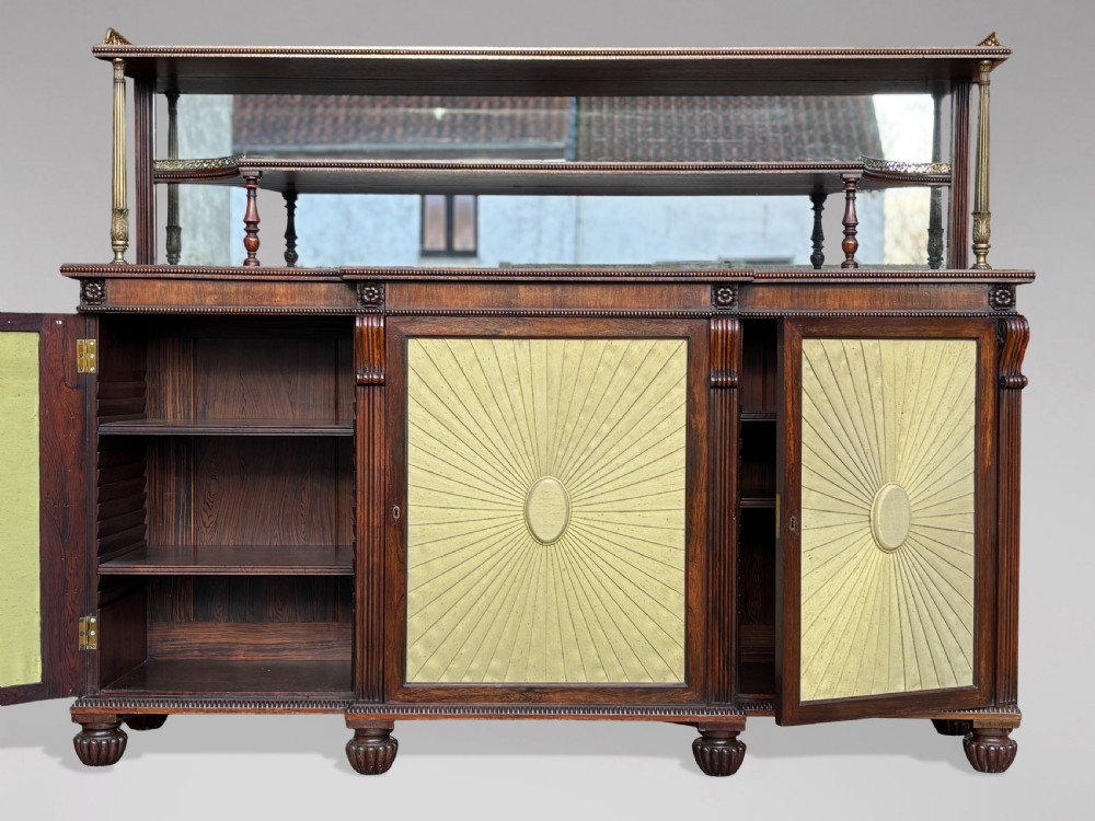 A Regency rosewood sideboard featuring three doors with sunburst pleated panels, a mirrored upper shelf supported by brass columns, and a pierced brass top gallery. View III