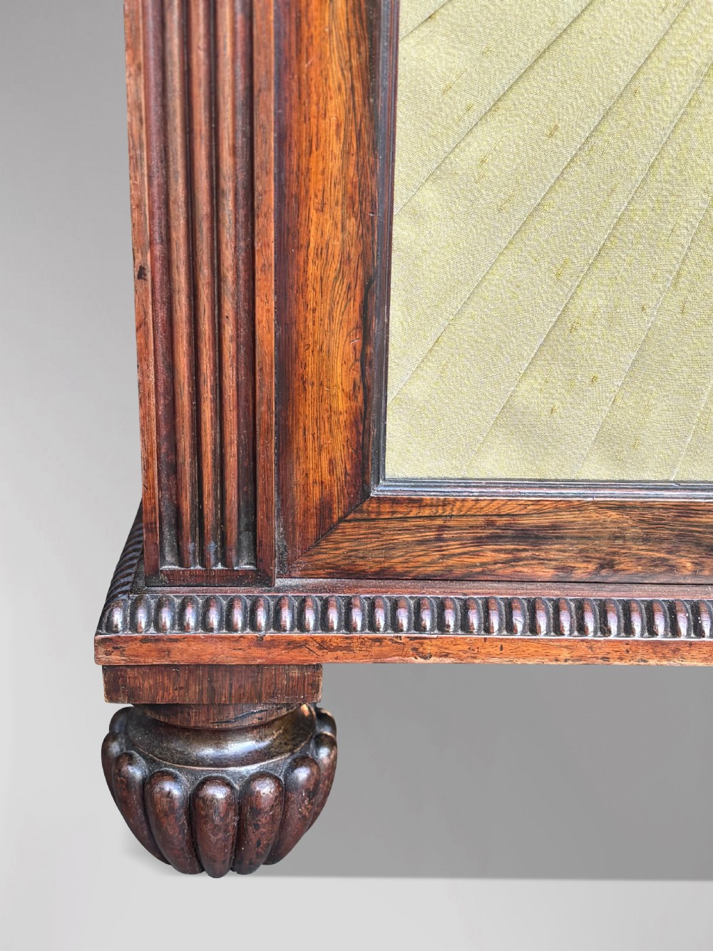 A Regency rosewood sideboard featuring three doors with sunburst pleated panels, a mirrored upper shelf supported by brass columns, and a pierced brass top gallery. View IV