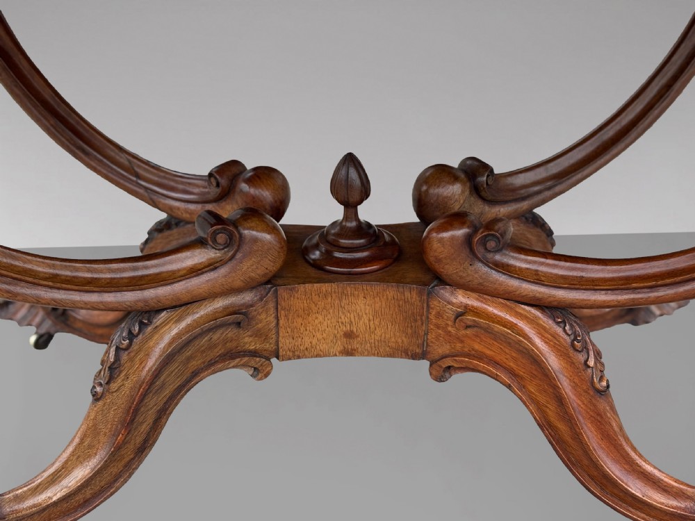 A 19th-century Victorian burr walnut centre table featuring a serpentine top with central floral marquetry and carved scroll legs on castors. View VIII
