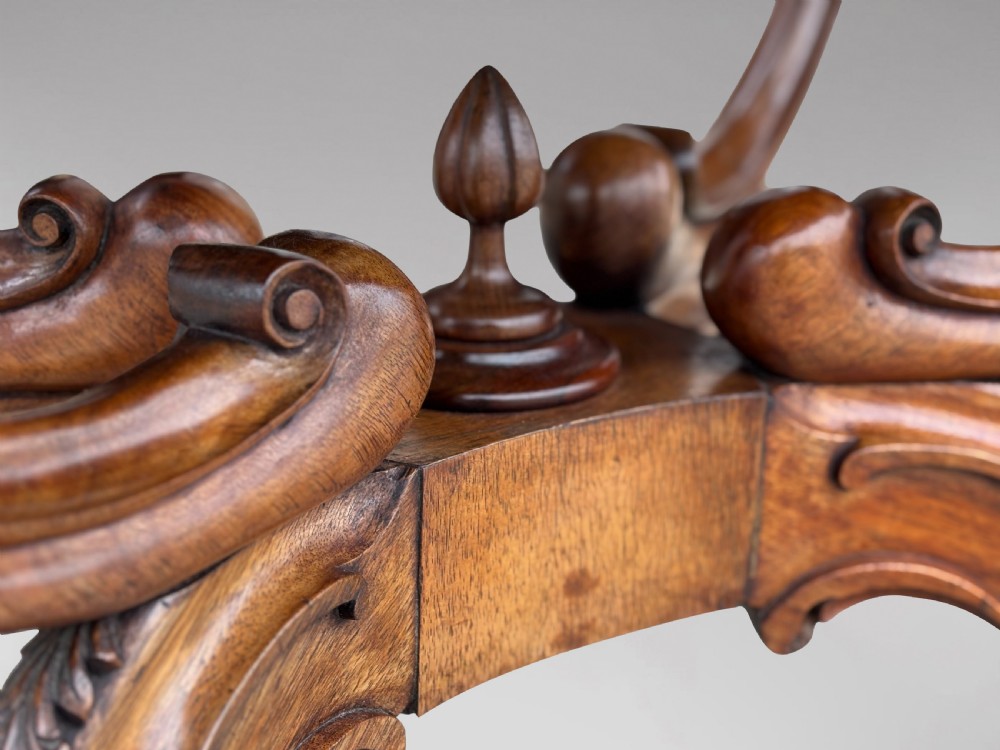 A 19th-century Victorian burr walnut centre table featuring a serpentine top with central floral marquetry and carved scroll legs on castors. View XIII