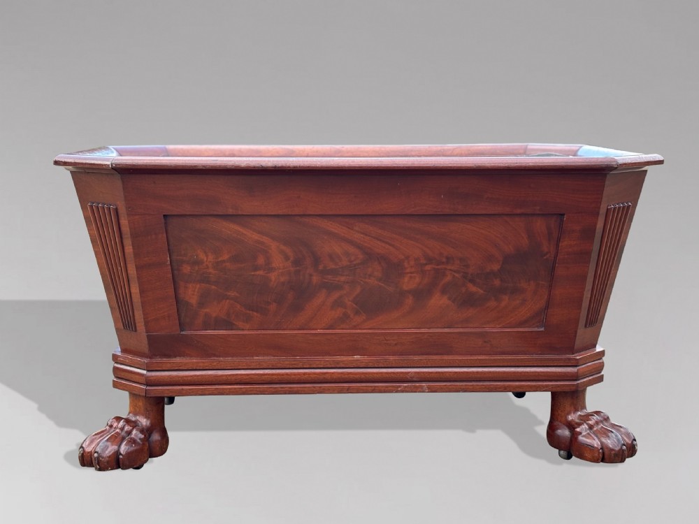 An early 19th-century Regency mahogany sarcophagus-shaped wine cooler featuring carved paw feet, fluted corner pilasters, and a metal liner. View II