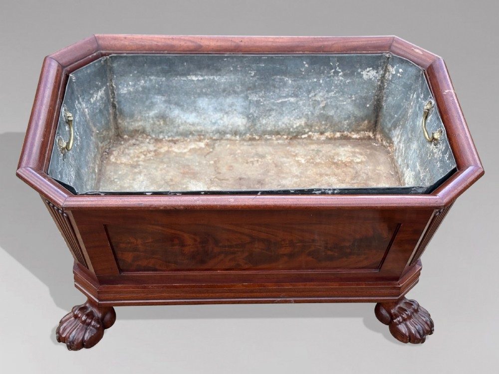 An early 19th-century Regency mahogany sarcophagus-shaped wine cooler featuring carved paw feet, fluted corner pilasters, and a metal liner. View III