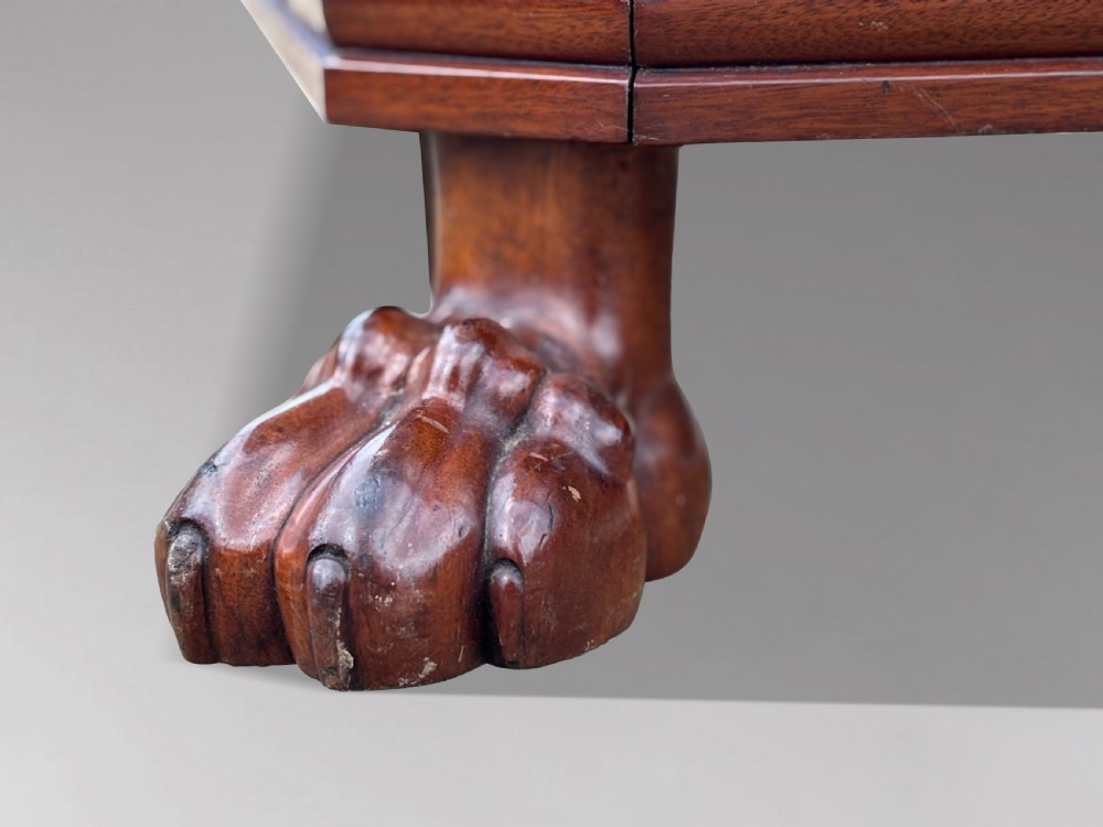 An early 19th-century Regency mahogany sarcophagus-shaped wine cooler featuring carved paw feet, fluted corner pilasters, and a metal liner. View V