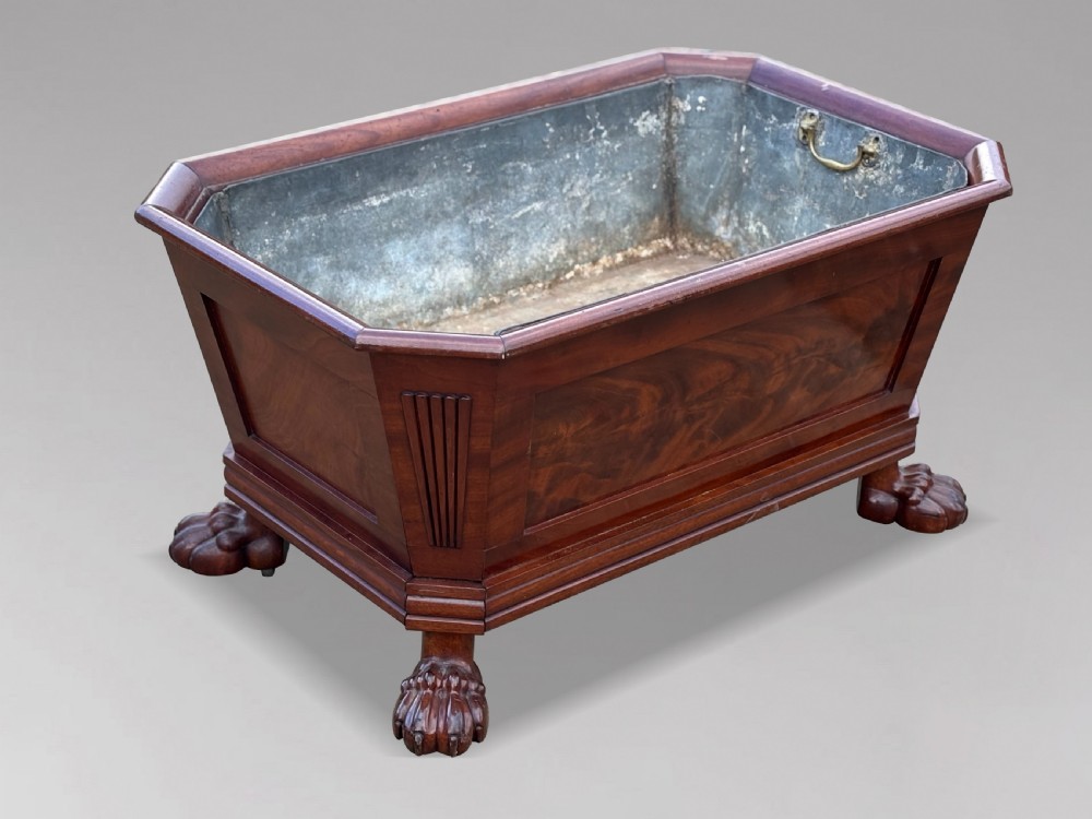 An early 19th-century Regency mahogany sarcophagus-shaped wine cooler featuring carved paw feet, fluted corner pilasters, and a metal liner. View VI