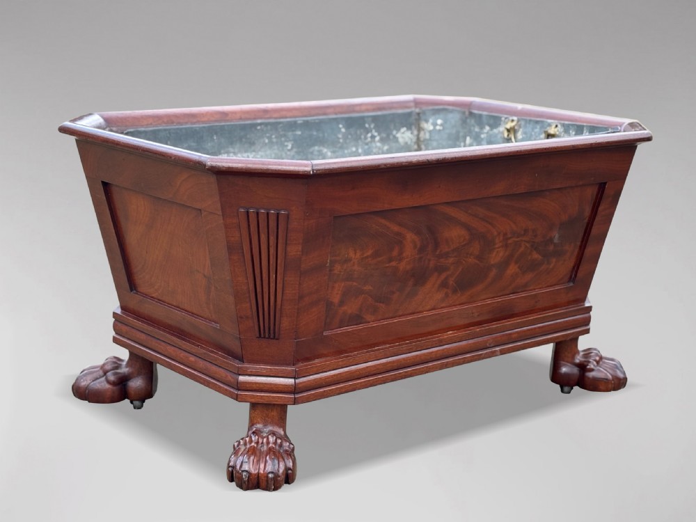 An early 19th-century Regency mahogany sarcophagus-shaped wine cooler featuring carved paw feet, fluted corner pilasters, and a metal liner. View VII
