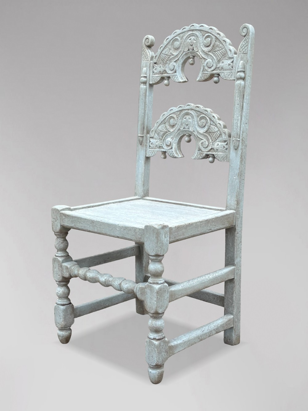 A set of eight light grey painted carved oak dining chairs featuring arched openwork backrests and turned legs. View III