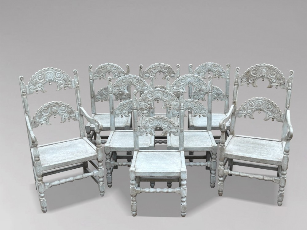 A set of eight light grey painted carved oak dining chairs featuring arched openwork backrests and turned legs. View IV