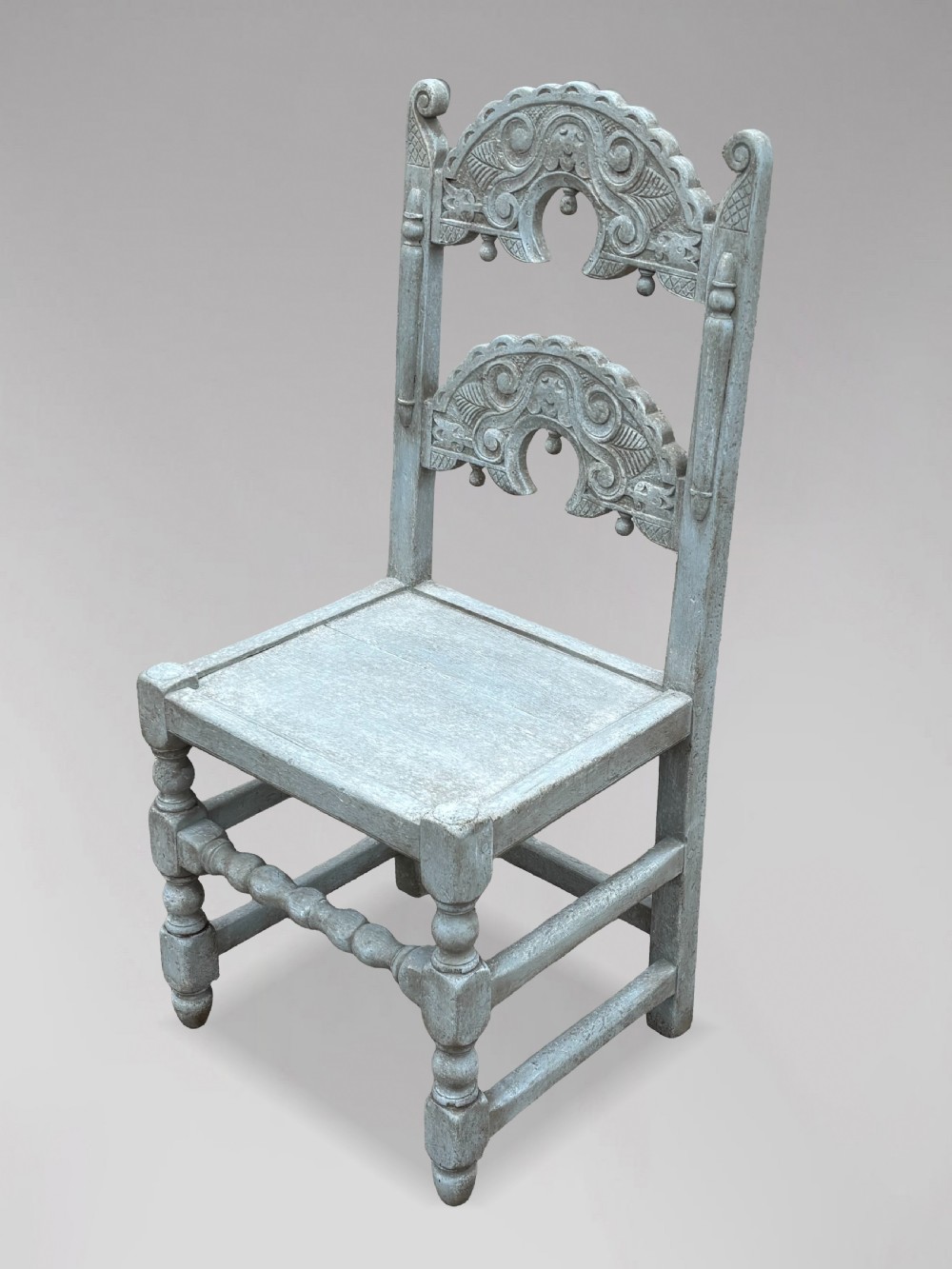 A set of eight light grey painted carved oak dining chairs featuring arched openwork backrests and turned legs. View V