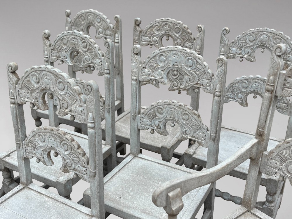A set of eight light grey painted carved oak dining chairs featuring arched openwork backrests and turned legs. View VI