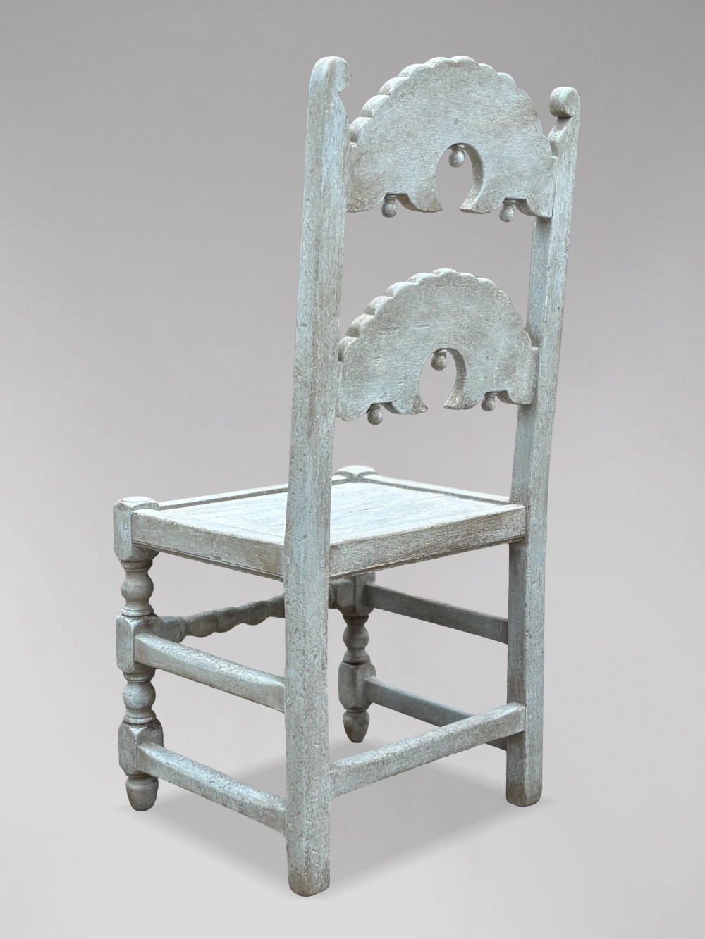 A set of eight light grey painted carved oak dining chairs featuring arched openwork backrests and turned legs. View VII