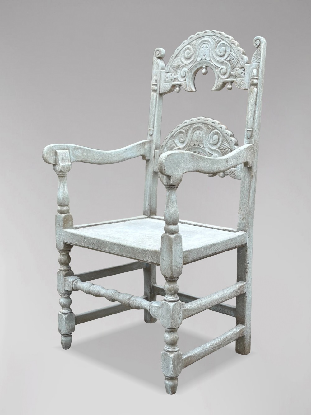 A set of eight light grey painted carved oak dining chairs featuring arched openwork backrests and turned legs. View VIII