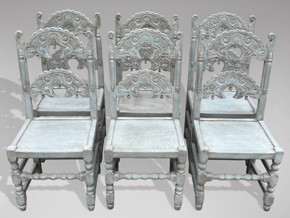 A set of eight light grey painted carved oak dining chairs featuring arched openwork backrests and turned legs. View XIII