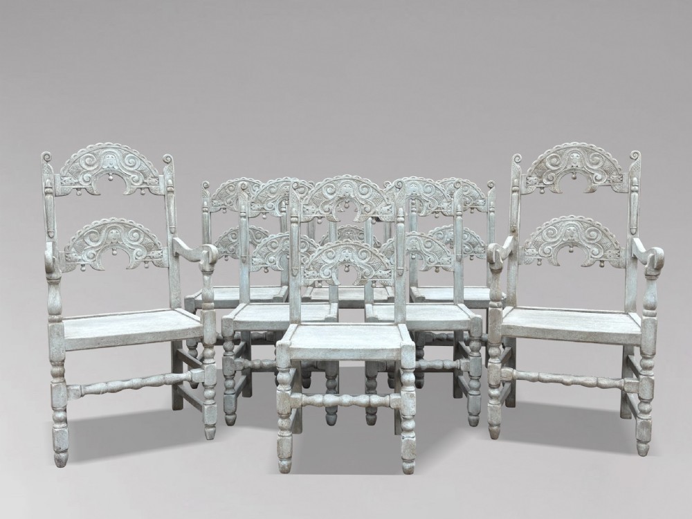 A set of eight light grey painted carved oak dining chairs featuring arched openwork backrests and turned legs. View XIV