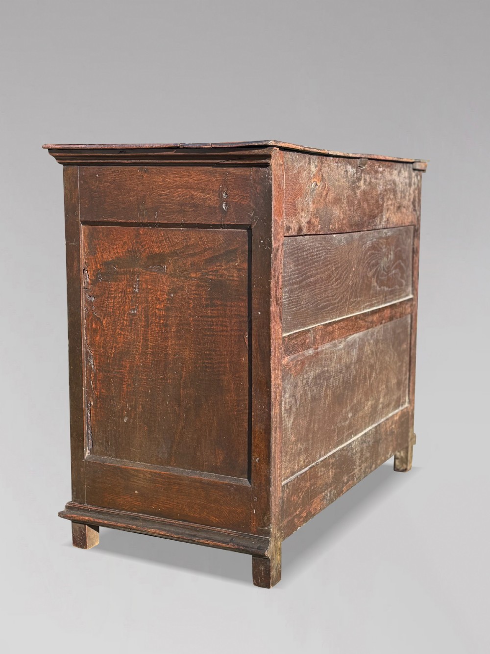 A 17th-century Charles II oak chest of drawers featuring geometric mitred mouldings, two short drawers over three long drawers, and brass teardrop handles. View VI
