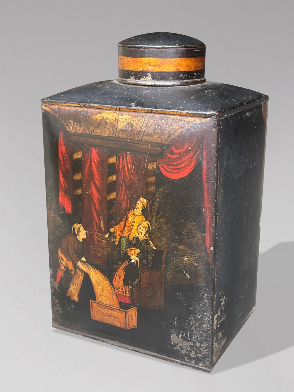 A set of three black rectangular antique toleware tea canisters hand-painted with detailed Chinoiserie figures and red drapery scenes. View II