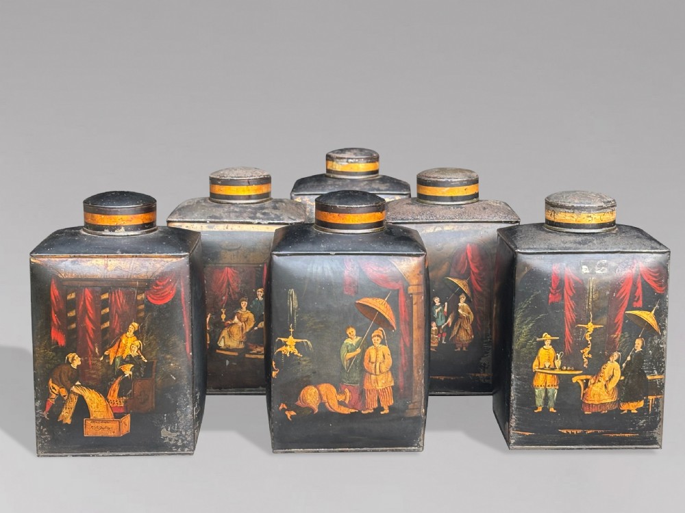 A set of three black rectangular antique toleware tea canisters hand-painted with detailed Chinoiserie figures and red drapery scenes. View V