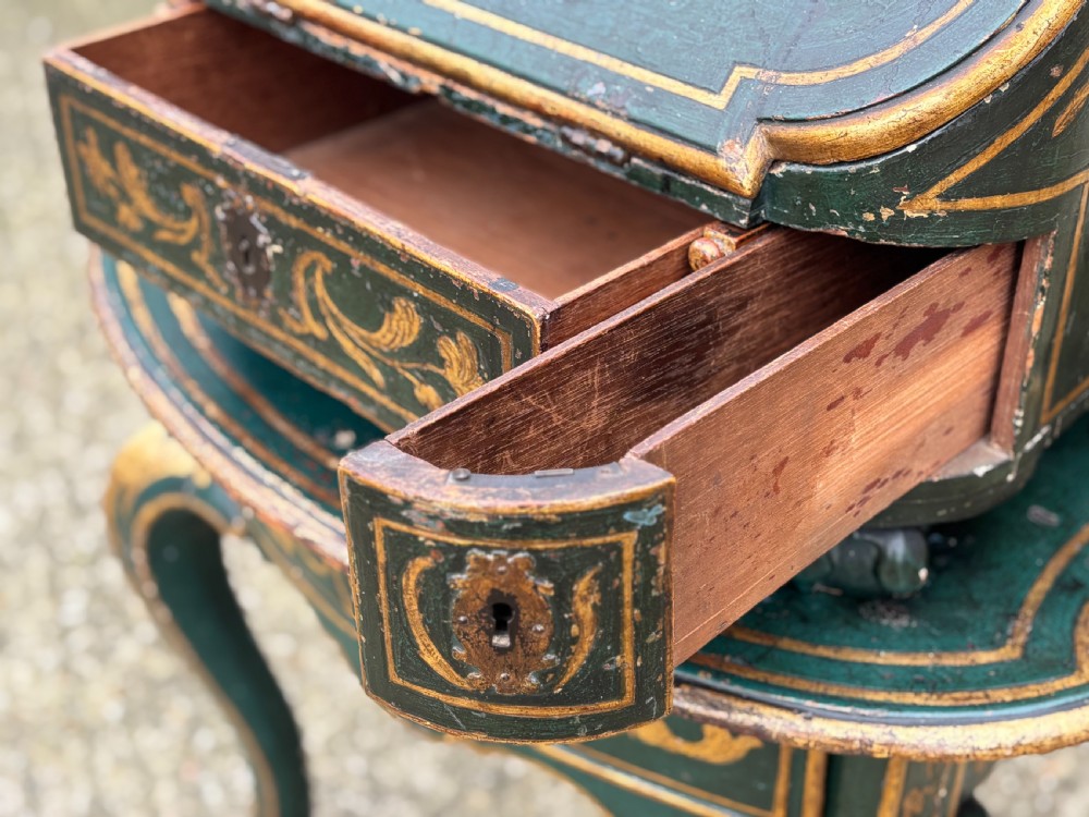 An 18th-century Venetian dark green lacquered travelling bureau with gilded floral scrollwork and fall-front writing flap resting on a matching cabriole-leg stand. View II