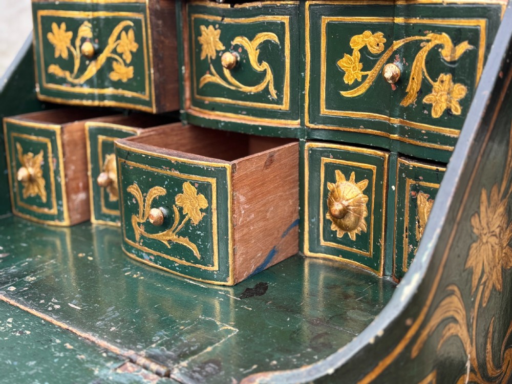 An 18th-century Venetian dark green lacquered travelling bureau with gilded floral scrollwork and fall-front writing flap resting on a matching cabriole-leg stand. View IV