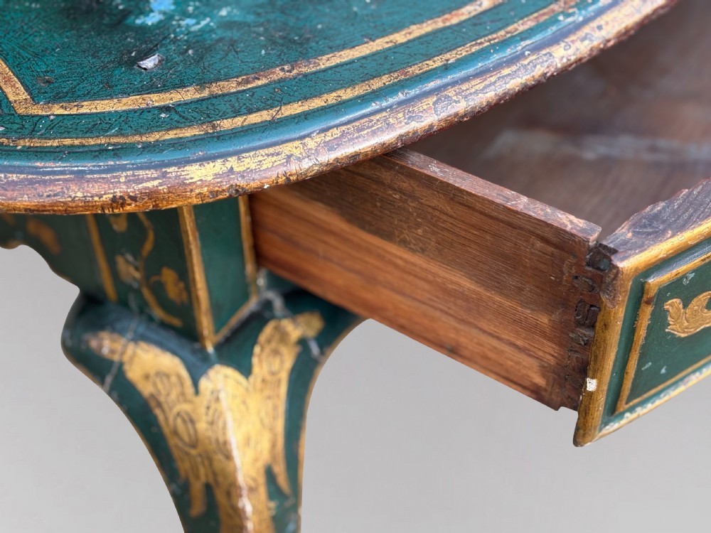 An 18th-century Venetian dark green lacquered travelling bureau with gilded floral scrollwork and fall-front writing flap resting on a matching cabriole-leg stand. View V