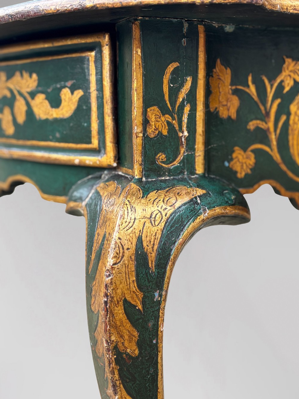 An 18th-century Venetian dark green lacquered travelling bureau with gilded floral scrollwork and fall-front writing flap resting on a matching cabriole-leg stand. View XII