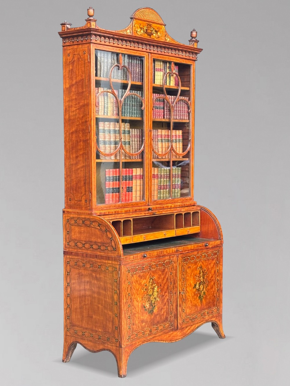 An 18th-century George III satinwood bureau bookcase featuring a glazed upper display cabinet above a cylinder writing section and two inlaid lower doors. View IV