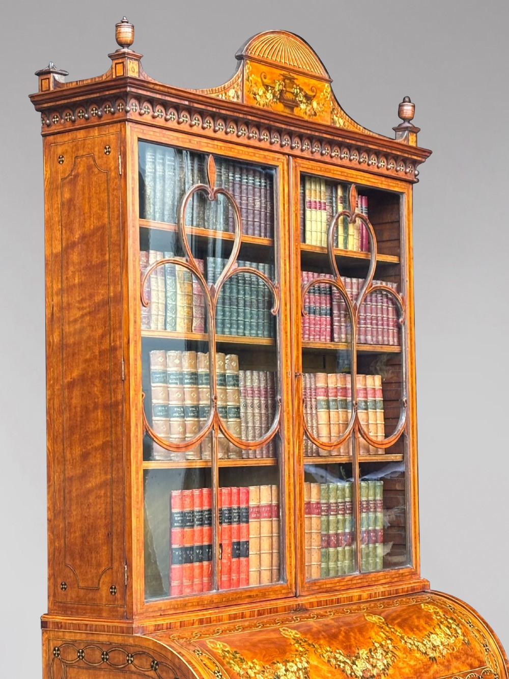 An 18th-century George III satinwood bureau bookcase featuring a glazed upper display cabinet above a cylinder writing section and two inlaid lower doors. View VII