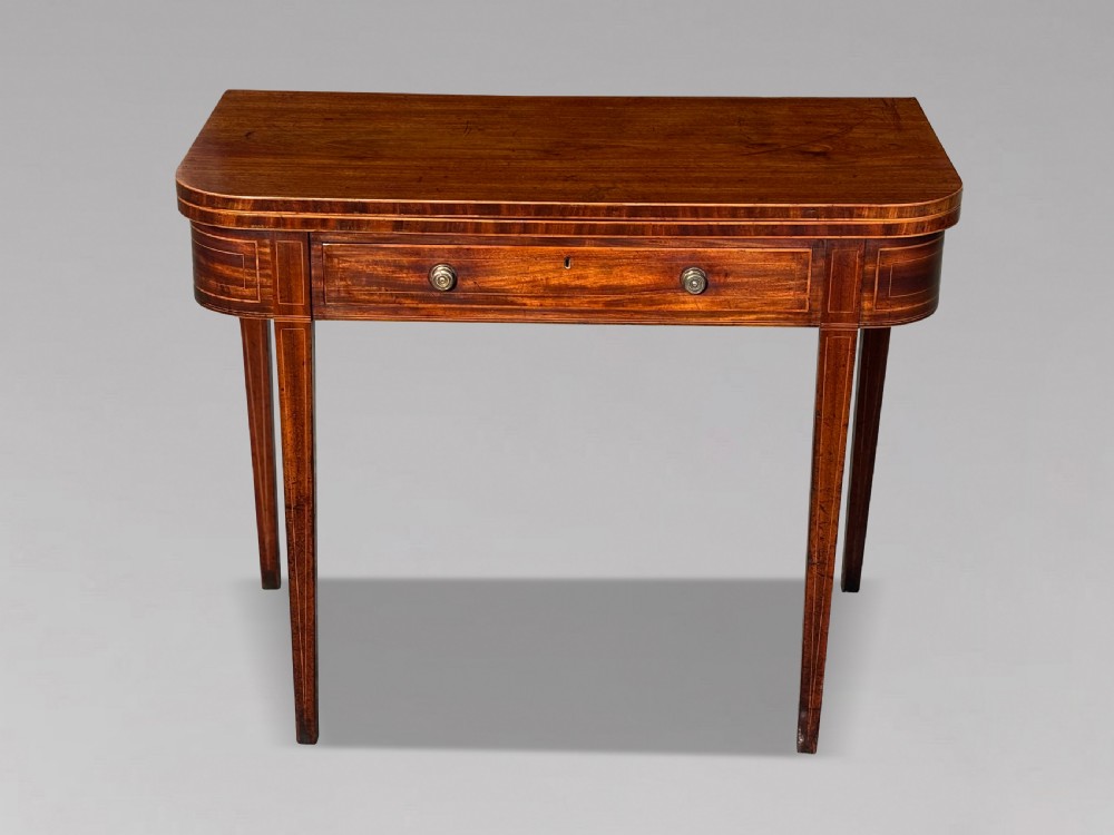An 18th-century George III mahogany fold-over tea table featuring fine string inlay, a frieze drawer with brass handles, and tapered legs. View II