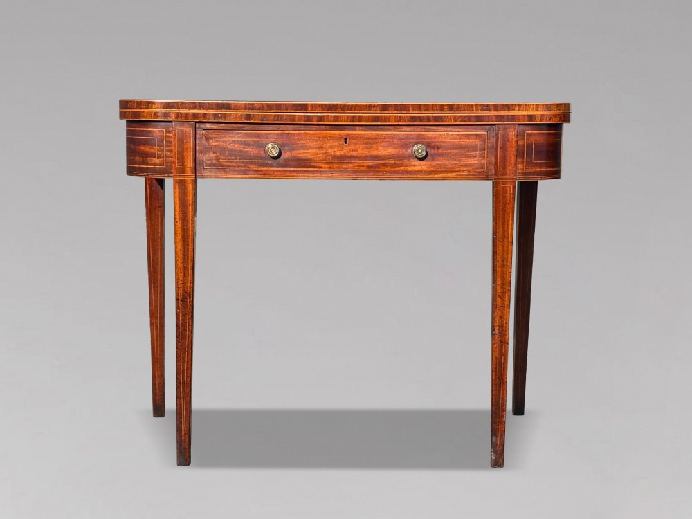 An 18th-century George III mahogany fold-over tea table featuring fine string inlay, a frieze drawer with brass handles, and tapered legs. View IX