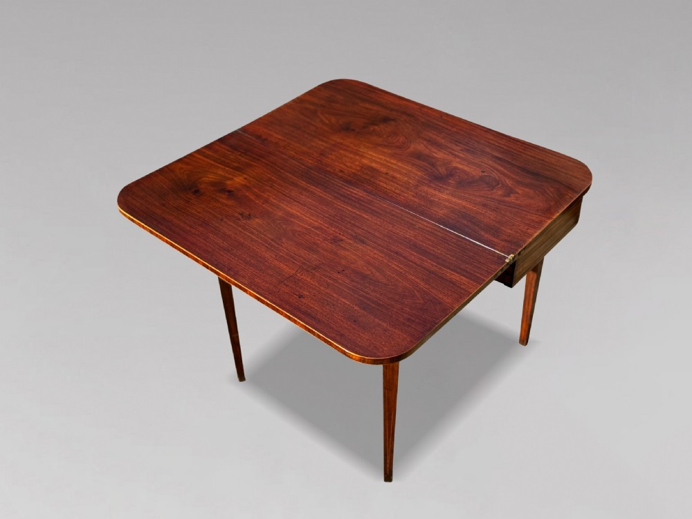 An 18th-century George III mahogany fold-over tea table featuring fine string inlay, a frieze drawer with brass handles, and tapered legs. View XIII