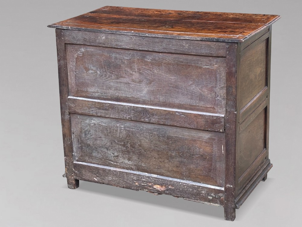 A 17th-century dark oak chest of drawers featuring three drawers decorated with raised geometric mitred mouldings, beaded trim details, and central brass drop handles. View III