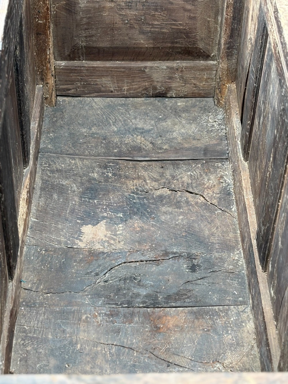A seventeenth-century dark oak joined coffer with four carved panelled sections, a carved top rail dated 1678, and carved initials IMS. View IV